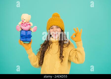 Mon cadeau préféré. prêt pour Noël. nouvelle année approche. préparation de Noël et des commerces. cheerful little girl love présente. petit enfant dans des vêtements chauds tenir cadeaux. hiver jours fériés. Banque D'Images