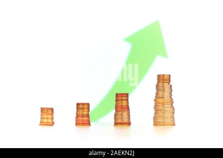 Fin de l'année financière positive avec concept rapport trimestriel. Quatre piles de pièces d'or avec l'augmentation de taille de gauche à droite et un vert vers le haut Banque D'Images