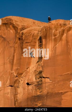 Un pas de géant au large de la face verticale de 400 pieds de la pierre tombale dans Kane Springs Canyon près de Moab, Utah. Banque D'Images