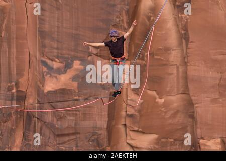 Un jeune homme slackline ou highlining des centaines de pieds au-dessus du Canyon de minéraux près de Moab, en Utah pendant un rassemblement highline. Banque D'Images