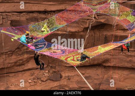 Un groupe de slackliners jouer sur l'espace net des centaines de pieds au-dessus du Canyon de minéraux près de Moab, en Utah pendant un rassemblement highline. Banque D'Images