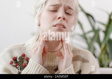 La jeune fille dans le chandail est malade. Le rhume et la grippe. Le patient a attrapé un rhume, une sensation de malaise. Mauvaise fille avec un mal de gorge. Banque D'Images