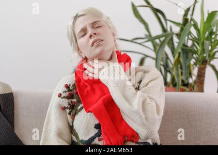 La jeune fille dans le chandail est malade. Le rhume et la grippe. Le patient a attrapé un rhume, une sensation de malaise. Mauvaise fille avec un mal de gorge. Close-up. Banque D'Images