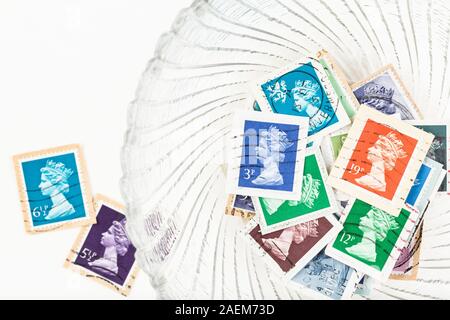 SEATTLE WASHINGTON - Le 5 décembre 2019 : timbres de Grande Bretagne sur le papier dans un bol avec 2 lâche sur fond blanc. Banque D'Images