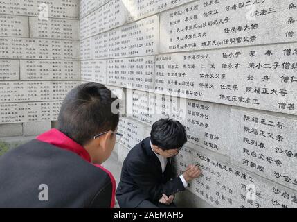 Les bénévoles d'universités locales retrouver les noms de victimes, qui ont été tués par les soldats japonais durant le massacre de Nanjing dans les Première Guerre mondiale Banque D'Images