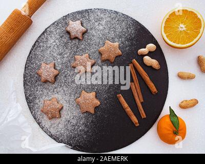 Des sablés de Noël star shape sugar cookies avec du sucre en poudre, la cannelle, vert sapin et cookie. Noël cuisson. Vue d'en haut Banque D'Images