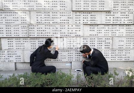 Les bénévoles d'universités locales retrouver les noms de victimes, qui ont été tués par les soldats japonais durant le massacre de Nanjing dans les Première Guerre mondiale Banque D'Images