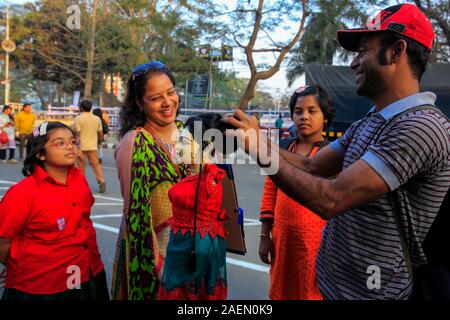 Une barrette vendeur montre différents types de coiffures pour attirer les acheteurs dans les rues de Dhaka, Bangladesh Banque D'Images