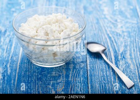 Fromage blanc frais dans une assiette sur un fond de bois. lieu pour le texte produit laitier nutritif. Banque D'Images