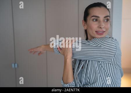 Femme réchauffe son épaule et smiling stock photo Banque D'Images