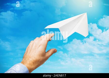 Un homme d'affaires a lancé un avion en papier dans le ciel comme un symbole de partir dans une nouvelle entreprise et la poursuite de l'avant Banque D'Images