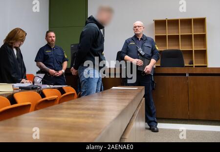 Munich, Allemagne. Dec 10, 2019. Les 21 ans (2e à partir de la droite), accusé de meurtre et de multiples tentatives de meurtre, se tient devant l'ouverture du procès avec son avocat Birgit Schwerdt (l) dans la salle d'audience du tribunal régional. Selon l'accusation, l'homme aurait tué son ex-petite amie a 25 ans avec un couteau dans l'appartement de sa famille à l'été 2018. Il est également dit d'avoir attaqué sa mère et ses 15 ans. Crédit : Sven Hoppe/DPA - ATTENTION : l'accusé a été pixelisées à la demande de son avocat/dpa/Alamy Live News Banque D'Images