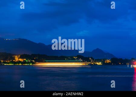 Bateau nautique sur le lac de Lucerne, dans une longue exposition de nuit avec vue sur la montagne en Suisse. Banque D'Images