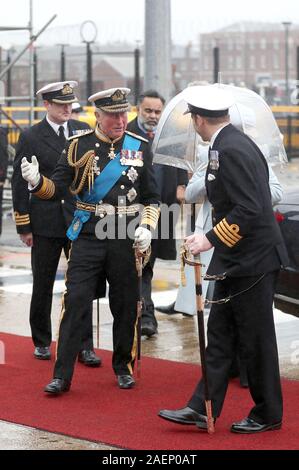 Le Prince de Galles et la duchesse de Cornouailles (caché) arrivent pour la cérémonie de mise en service des porte-avions de la Royal Navy, le HMS Prince de Galles, à la base navale de Portsmouth. Banque D'Images