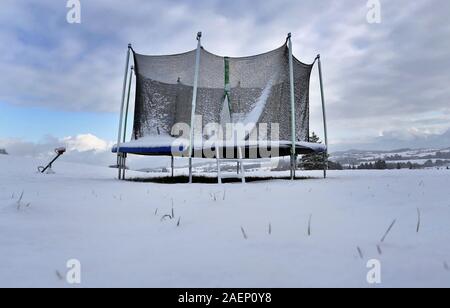 Oy Mittelberg, Allemagne. Dec 10, 2019. Un trampoline couverte de neige se trouve en face d'une ferme dans le paysage d'hiver. Credit : Karl-Josef Opim/dpa/Alamy Live News Banque D'Images