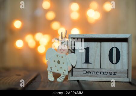 Calendrier en bois Cube indiquant la date du 10 décembre avec ange sur fond flou. Calendrier de l'Avent, Noël arrière-plan, Copy space Banque D'Images