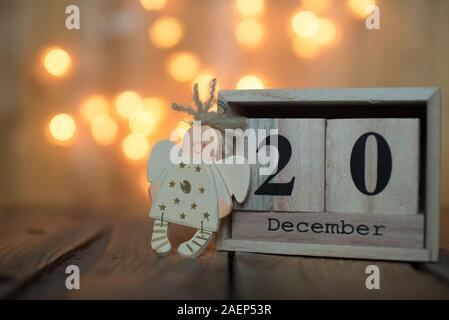 Calendrier en bois Cube affichant la date le 20 décembre avec ange sur fond flou. Calendrier de l'Avent, Noël arrière-plan, Copy space Banque D'Images