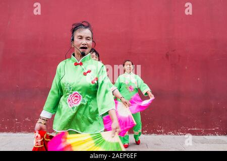 8 mars 2019 : rassemblement de personnes et de danse avec des robes traditionnelles en face de la célèbre Porte de Chaoyang à Jianshui, Yunnan, Chine Banque D'Images