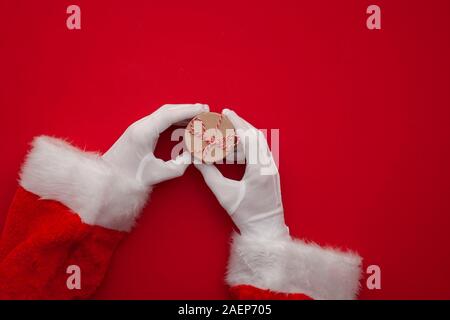 Santa Claus hand holding a Christmas present Banque D'Images