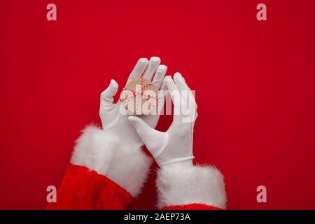 Santa Claus hand holding a Christmas present Banque D'Images