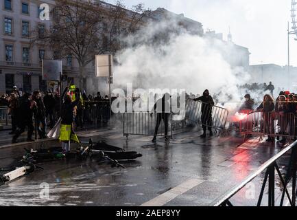 Lyon, France. Dec 10, 2019. La construction d'une barricade de manifestants au cours d'une manifestation dans le cadre de grèves et manifestations contre la réforme des retraites en France à la place Bellecour. La grève générale et des manifestations violentes à Lyon également conserver les fans de l'équipe de football Bundesliga RB Leipzig sur leurs orteils. À midi, le mardi, le club a mis en garde ses partisans de ne pas répondre à la Place Bellecour pour un entraînement commun pour le stade. Peu de temps après, il y a eu des affrontements entre manifestants et policiers sur et autour de la place. Dpa : Crédit photo alliance/Alamy Live News Banque D'Images