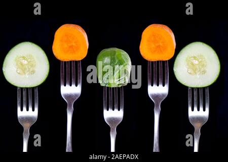 Les carottes, les concombres et les choux de Bruxelles sur les fourches. Manger et obtenir tous vos éléments nutritifs ! Banque D'Images