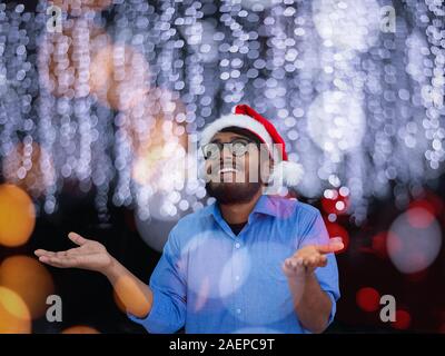 L'homme indien traditionnel port Santa Claus hat on chalkboard background studio la peau sombre Noël le nouvel an Banque D'Images