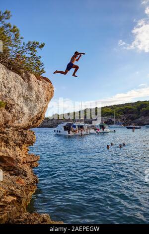 Garçon plongeant de rochers à Cala en Turqueta, Minorque, Iles Baléares, Espagne Banque D'Images