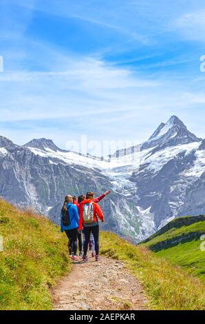Grindelwald, Suisse - le 16 août 2019 : l'Été alpin environnant. Les jeunes touristes féminines et Alpes Suisses dans l'arrière-plan. Photographié sur le sentier à partir de Grindelwald à Bachalp. Banque D'Images