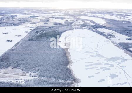 Drone aérien vue d'un lac gelé en partie avec les correctifs non gelé et la glace se fissure sur un matin d'hiver. Tartu, Estonie. Banque D'Images