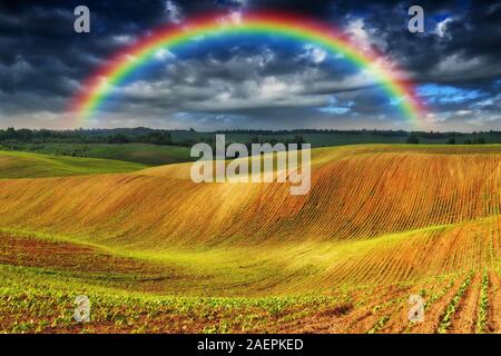 Dans le domaine de l'arc-en-ciel ciel pittoresque. sur un terrain vallonné après un orage. Banque D'Images