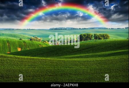 Dans le domaine de l'arc-en-ciel ciel pittoresque. sur un terrain vallonné après un orage. Banque D'Images