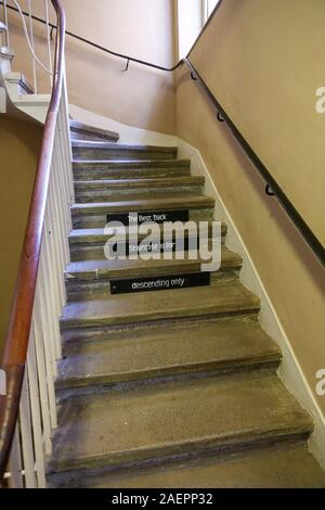 L'arrière des escaliers ou fonctionnaires de l'escalier avec un panneau disant 'le meilleur retour d'escalier est en ordre décroissant pour seulement', à Attingham Park, Shropshire, England, UK Banque D'Images