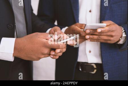 Les hommes d'affaires de la saisie sur les téléphones cellulaires, Close up Banque D'Images