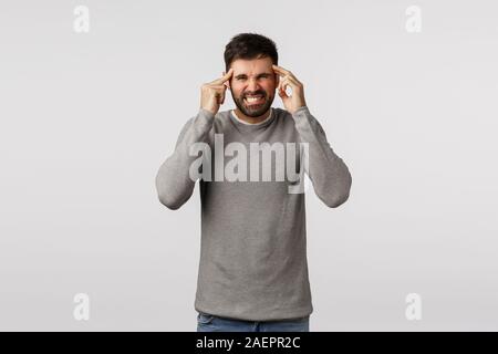 Hangover, vacances et soins de concept. L'irritation et la peine des profils homme barbu, grimaces de douleur, serrez les dents, de toucher des temples, tête de massage Banque D'Images