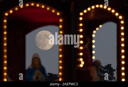 Stuttgart, Allemagne. Dec 10, 2019. La lune se lève derrière les lumières du marché de Noël. Crédit : Sébastien Gollnow/dpa/Alamy Live News Banque D'Images