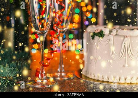 Noël et Nouvel An fête concept. Maison de champagne, des verres et des gâteaux près de l'arbre de Noël avec des décorations. Banque D'Images