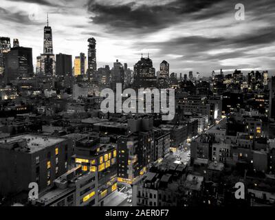 New York City skyline view dans la nuit avec un éclairage jaune contraste avec le noir et blanc de bâtiments bas Manhattan Banque D'Images