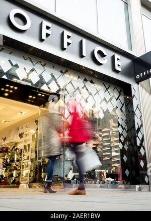 Bureau, Oxford Street, Londres. Quelques acheteurs devant l'entrée de la chaîne de magasins de chaussures Office in London's central shopping district. Banque D'Images