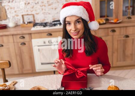 Femme joyeuse de l'ouverture d'une boîte cadeau de Noël Banque D'Images