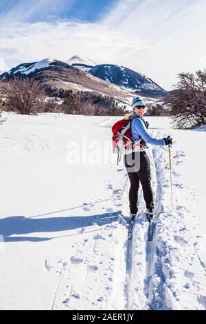Une femme d'âge moyen le ski de fond sur les contreforts des Montagnes La Sal dans le sud-est de l'Utah, USA. Banque D'Images