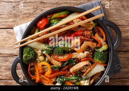 Sauté de porc aux sains différents légumes close-up dans une casserole sur la table. Haut horizontale Vue de dessus Banque D'Images