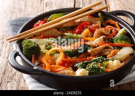 Sauté de porc aux sains différents légumes close-up dans une casserole sur la table horizontale. Banque D'Images