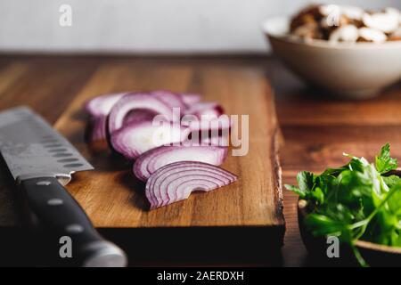 Close-up de planche à découper en bois, le couteau et l'oignon sur une table de cuisine. Concept de cuisson. Banque D'Images