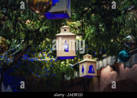 Lanterne lumière bleue comme décorations de Noël et des globes accroché sur les branches d'arbre sapin vert au-dessus de la rue. Belle ambiance à l'extérieur avant de gagner Banque D'Images