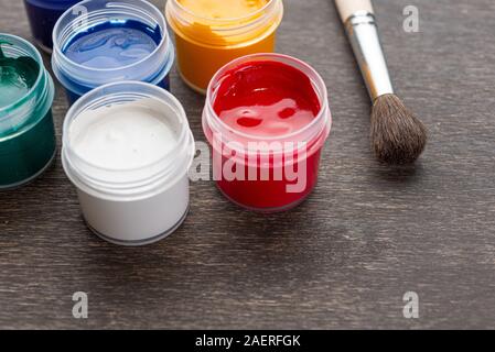 Regarder sur trois couleurs de peinture peindre debout sur un plancher de bois de style shabby Banque D'Images