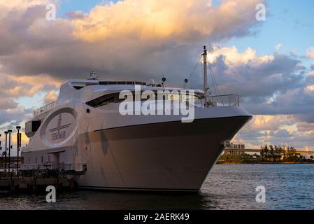 Un grand yacht à moteur amarré au Bay près de chemin de randonnée, avec port de Miami dans la distance Banque D'Images