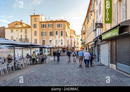 Le Français Local prendre le petit-déjeuner dans un café avec terrasse en plein air près du marché aux puces en plein air dans la station balnéaire d'Antibes, France, sur la côte d'Azur. Banque D'Images