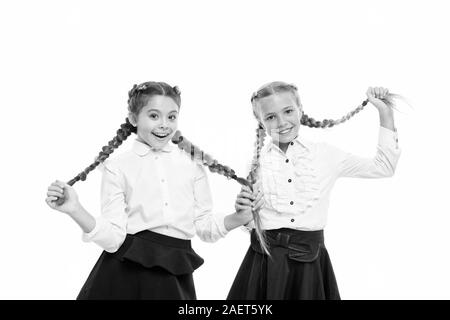 Aider les cheveux pousser plus vite. Adorables petits enfants prendre soin de cheveux longs. Petit mignon girl holding longs cheveux tresses, isolé sur blanc. Porter les cheveux longs en tresses pour l'école. Banque D'Images