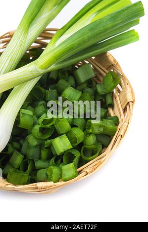 Les oignons verts frais mûrs (échalotes ou oignons verts) avec oignons hachés dans panier sur fond blanc Banque D'Images